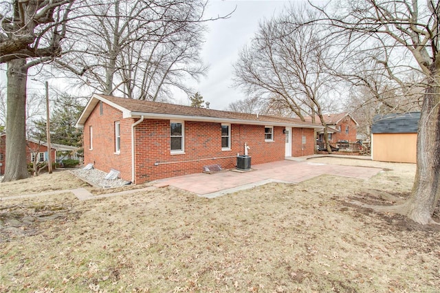 429 Oak St, East Alton, IL 62024 - back of house with brick siding, a patio, a storage shed, an outbuilding, and central AC unit