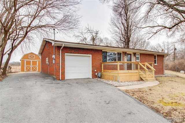 429 Oak St, East Alton, IL 62024 - single story home with a garage, brick siding, asphalt driveway, a porch, and a storage shed