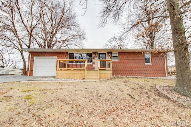 429 Oak St, East Alton, IL 62024 - ranch-style house with an attached garage, brick siding, asphalt driveway, and a porch