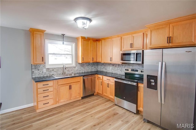 429 Oak St, East Alton, IL 62024 - kitchen featuring stainless steel appliances, dark countertops, decorative backsplash, and light wood finished floors