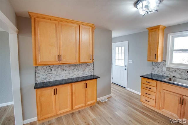 429 Oak St, East Alton, IL 62024 - kitchen with backsplash, light wood-style floors, light brown cabinetry, and dark countertops
