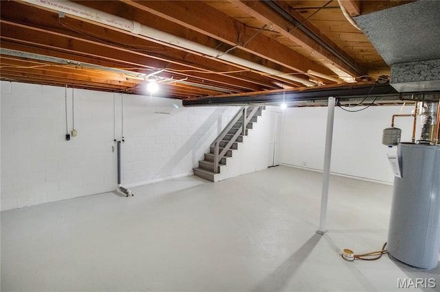 429 Oak St, East Alton, IL 62024 - below grade area featuring water heater, stairway, and concrete block wall