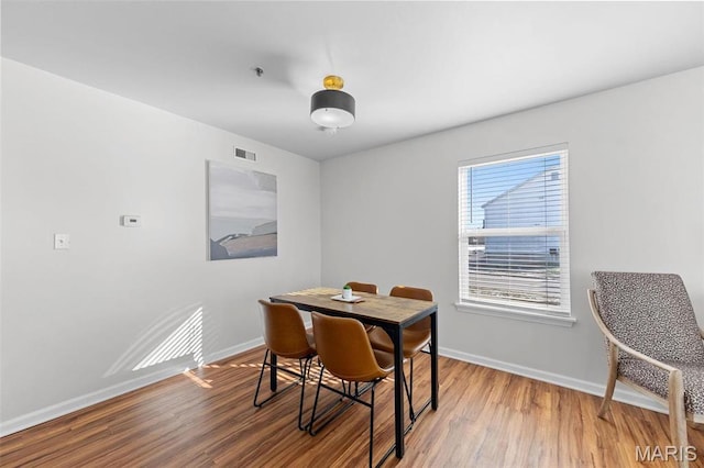 dining space featuring baseboards and wood finished floors