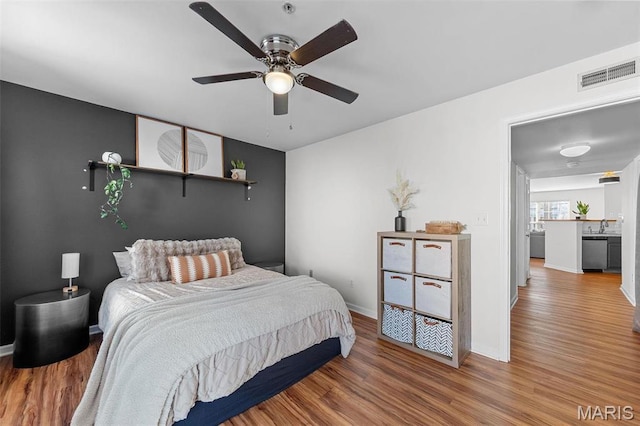bedroom with wood finished floors, baseboards, and ceiling fan
