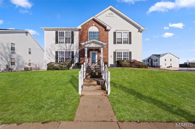 traditional home with a front lawn and brick siding