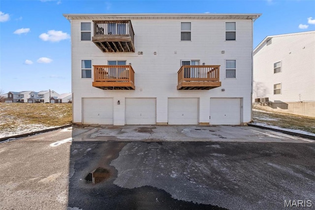 back of house with a garage and central AC