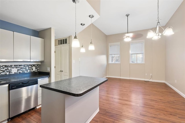 1052 S Kingshighway Blvd, Saint Louis, MO 63110 - kitchen with stainless steel dishwasher, hardwood / wood-style floors, backsplash, dark countertops, and decorative light fixtures