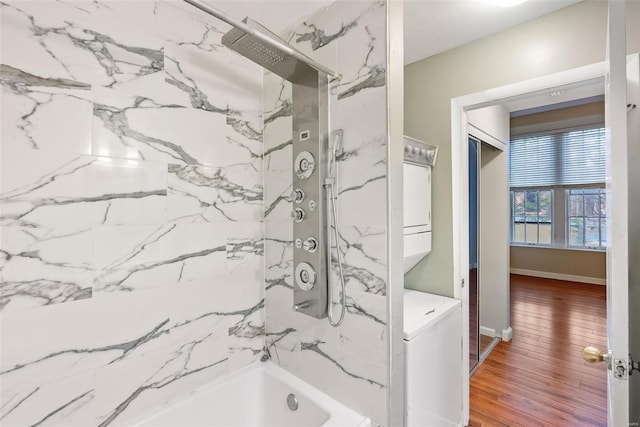 1052 S Kingshighway Blvd, Saint Louis, MO 63110 - bathroom featuring stacked washer and clothes dryer, wood finished floors, and a combined bath / shower with marble appearance