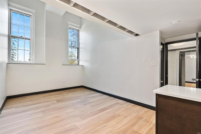 1052 S Kingshighway Blvd, Saint Louis, MO 63110 - spare room with light wood finished floors, healthy amount of natural light, and baseboards