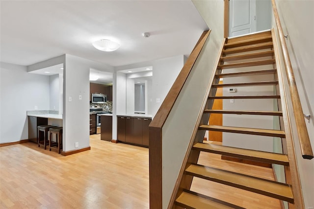 1052 S Kingshighway Blvd, Saint Louis, MO 63110 - stairs with wood finished floors, baseboards, and recessed lighting