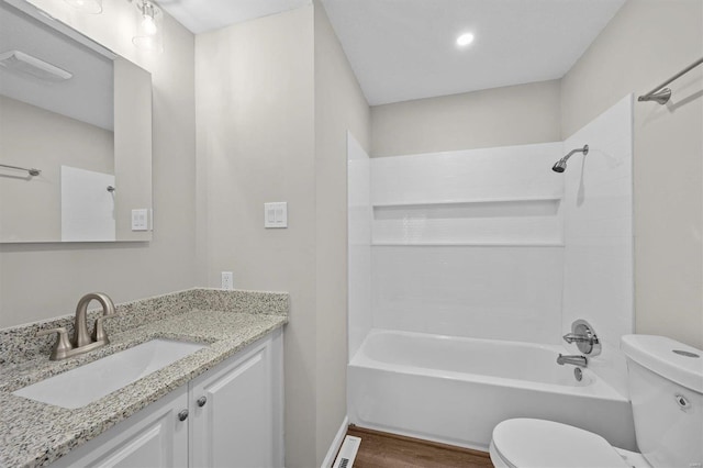 bathroom with toilet, wood finished floors, washtub / shower combination, and vanity