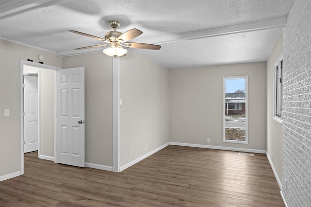 unfurnished bedroom featuring a textured ceiling, wood finished floors, baseboards, ceiling fan, and ornamental molding