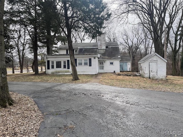 12255 Benham Rd, Saint Louis, MO 63138 - colonial inspired home with a shed, a chimney, and a shingled roof