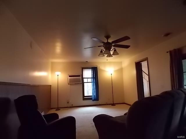 109 E Hicks, Cardwell, MO 63829 - living room with a ceiling fan, carpet flooring, a wall mounted air conditioner, and baseboards