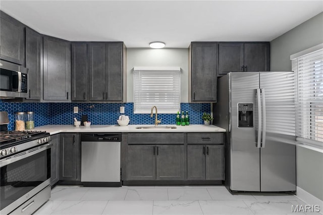 5807 Columbia Ave, Saint Louis, MO 63139 - kitchen featuring a sink, stainless steel appliances, light marble finish flooring, light countertops, and tasteful backsplash