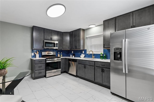 5807 Columbia Ave, Saint Louis, MO 63139 - kitchen with appliances with stainless steel finishes, light marble finish floors, light countertops, backsplash, and a sink