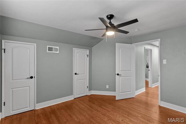 5807 Columbia Ave, Saint Louis, MO 63139 - unfurnished bedroom featuring baseboards, wood finished floors, vaulted ceiling, and a ceiling fan