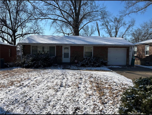 single story home featuring an attached garage, concrete driveway, and brick siding