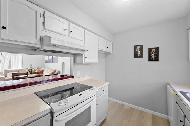 kitchen with white electric stove, under cabinet range hood, baseboards, light wood finished floors, and white cabinets