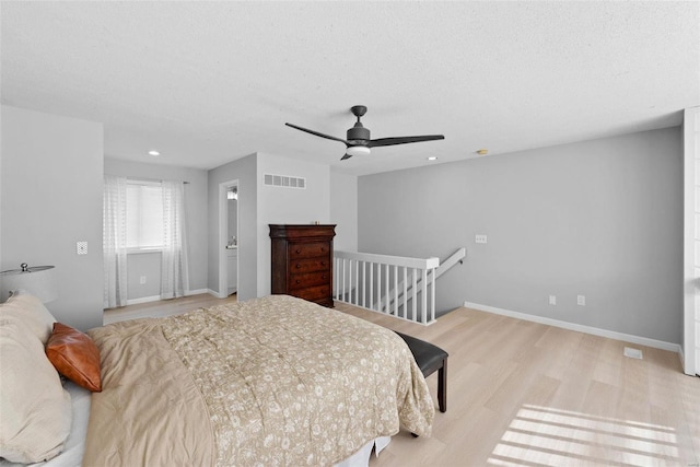 bedroom featuring wood finished floors, a textured ceiling, baseboards, recessed lighting, and a ceiling fan