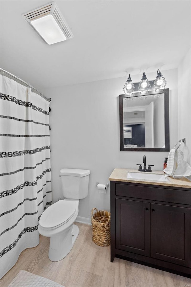 full bath with wood finished floors, toilet, vanity, baseboards, and curtained shower