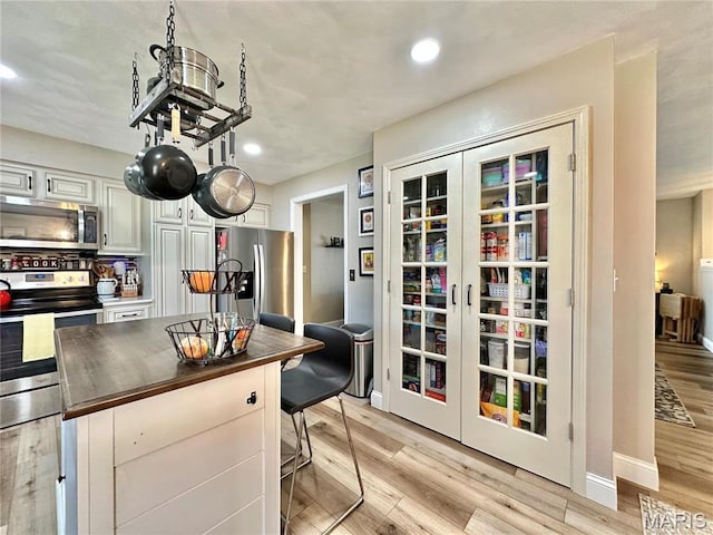 6 Ravenwood Cir, Ofallon, IL 62269 - kitchen featuring stainless steel appliances, light wood-type flooring, white cabinets, recessed lighting, and baseboards