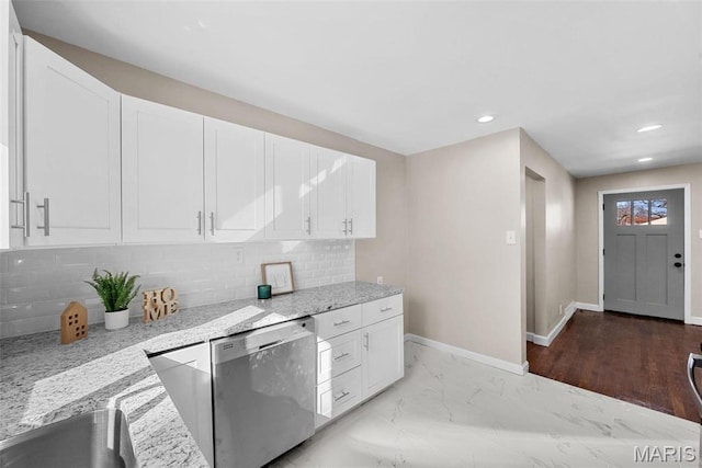 8646 Spoon Dr, Saint Louis, MO 63132 - kitchen with stainless steel dishwasher, white cabinetry, light stone countertops, backsplash, and baseboards