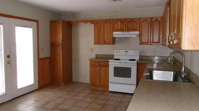 kitchen featuring white range with electric cooktop, a sink, under cabinet range hood, brown cabinets, and french doors
