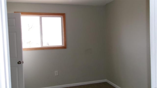 unfurnished room with baseboards
