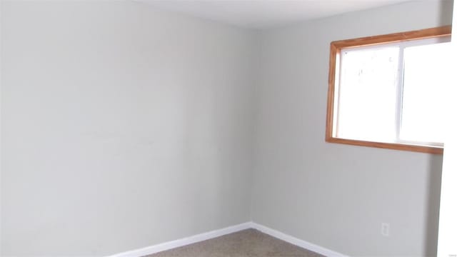 carpeted empty room featuring baseboards