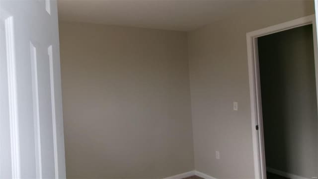 unfurnished room featuring baseboards