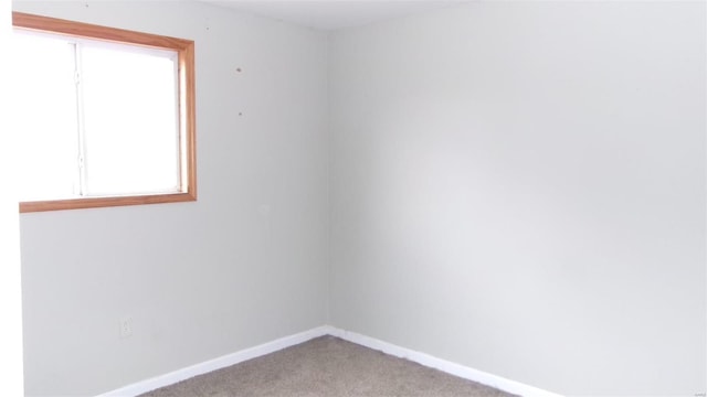 empty room featuring light colored carpet and baseboards