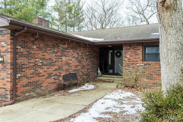 3 Echo Ln, Centralia, IL 62801 - view of exterior entry featuring brick siding, a chimney, a patio, and a shingled roof