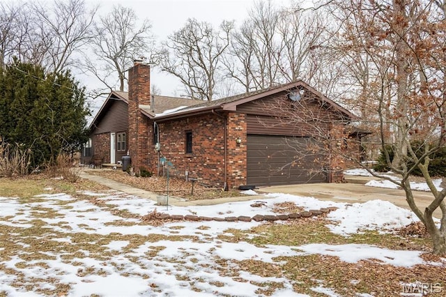 3 Echo Ln, Centralia, IL 62801 - view of snow covered exterior featuring a garage, brick siding, and a chimney