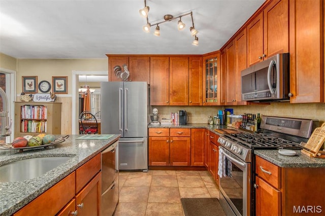 3 Echo Ln, Centralia, IL 62801 - kitchen with stainless steel appliances, a sink, dark stone countertops, and brown cabinets