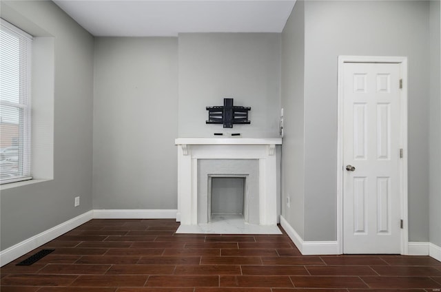 7915 S Broadway, Saint Louis, MO 63111 - unfurnished living room featuring wood tiled floors, baseboards, and a fireplace with flush hearth