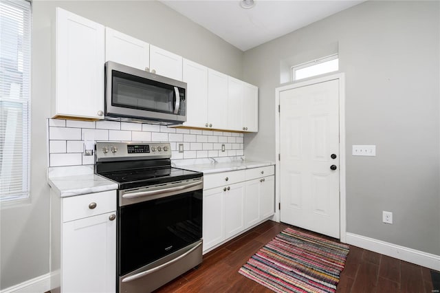7915 S Broadway, Saint Louis, MO 63111 - kitchen with appliances with stainless steel finishes, decorative backsplash, dark wood-type flooring, and white cabinetry