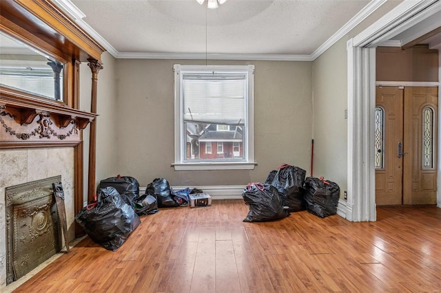 5029 Wells Ave, Saint Louis, MO 63113 - dining space featuring hardwood / wood-style flooring, ornamental molding, a tile fireplace, a textured ceiling, and a ceiling fan