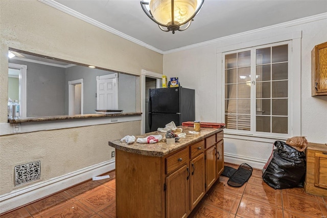 5029 Wells Ave, Saint Louis, MO 63113 - kitchen with freestanding refrigerator, crown molding, brown cabinetry, a kitchen island, and baseboards