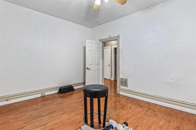 5029 Wells Ave, Saint Louis, MO 63113 - spare room with baseboards, wood finished floors, a ceiling fan, and a textured wall