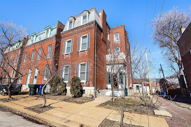 1317 Shenandoah Ave, Saint Louis, MO 63104 - view of front of house with brick siding, a high end roof, and a chimney