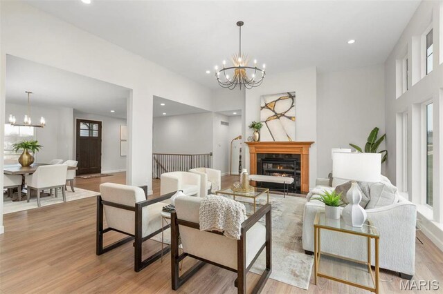 212 Terradel Trl, Foristell, MO 63348 - living room with a chandelier, light wood-type flooring, recessed lighting, and a glass covered fireplace