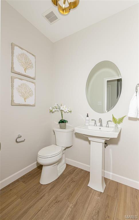212 Terradel Trl, Foristell, MO 63348 - half bathroom with toilet, wood finished floors, baseboards, and a chandelier