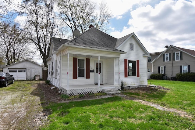 610 Panhorst St, Staunton, IL 62088 - view of front of home with a porch, a detached garage, a front lawn, an outbuilding, and a shingled roof