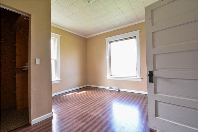610 Panhorst St, Staunton, IL 62088 - unfurnished bedroom with crown molding, multiple windows, dark wood finished floors, and baseboards