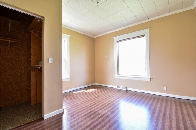 610 Panhorst St, Staunton, IL 62088 - unfurnished bedroom featuring dark wood finished floors, crown molding, multiple windows, and baseboards