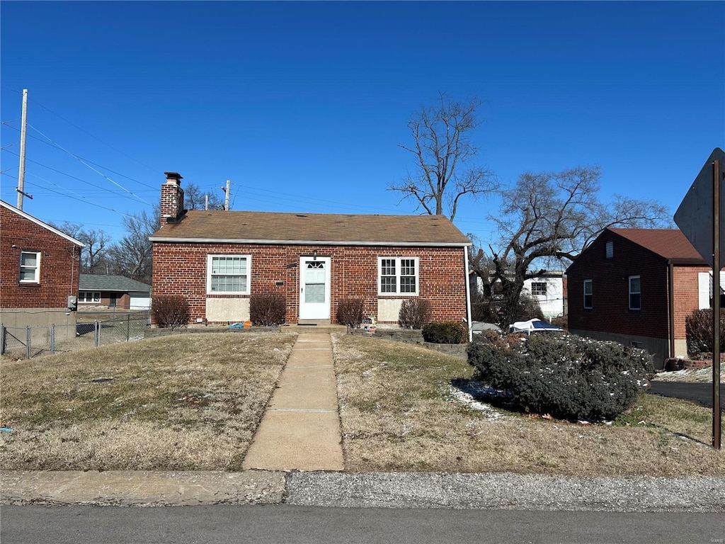 2051 Park Ln, Saint Louis, MO 63136 - view of front facade featuring a chimney, fence, and brick siding