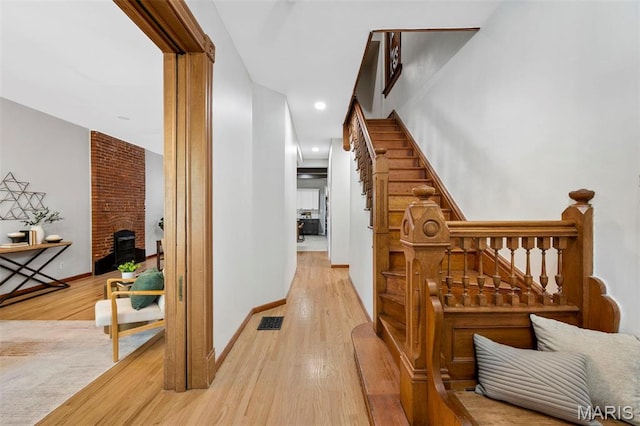corridor featuring light wood-type flooring, stairs, recessed lighting, and baseboards