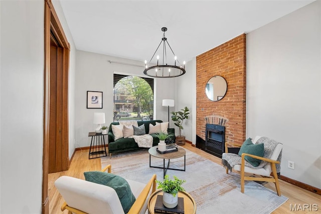 living area with light wood finished floors, a chandelier, and baseboards