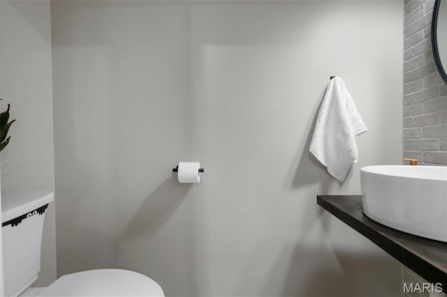 half bath featuring toilet and a sink